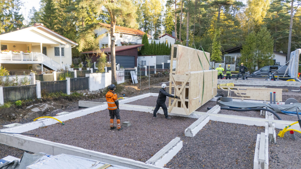 Seinäelementtiä ohjataan noston aikana paikoilleen omakotitalotyömaalla Espoossa.