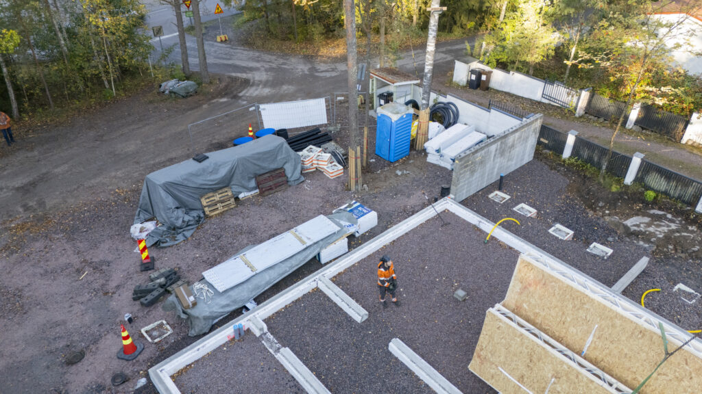 Omakotitalon seinäelementtejä kuljetusautossa ja asennettuna Espoon rakennustyömaalla.